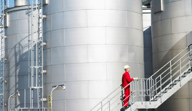Mitarbeiter vor Industrielagertanks zur Aufbewahrung von Flüssigkeiten
